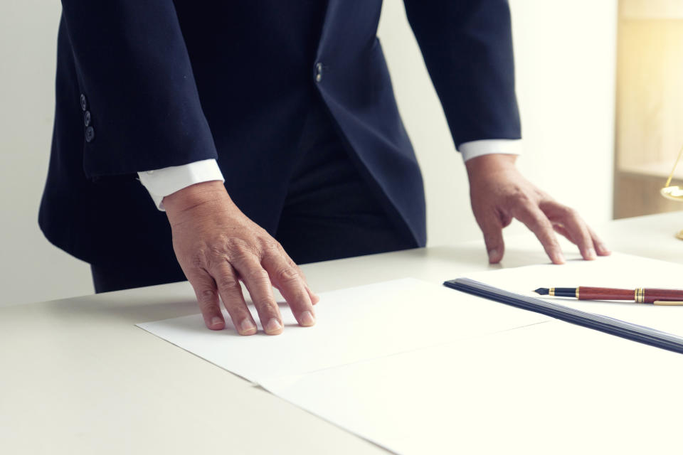 Businessman standing with his hands on a desk