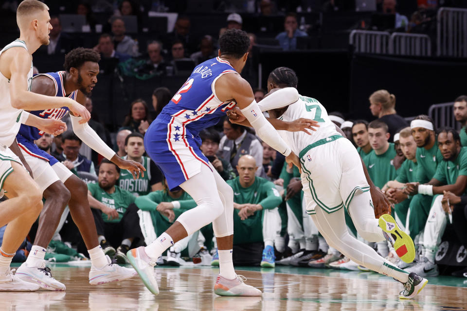 Wearing his shorts backwards, Boston Celtics guard Jaylen Brown (7) drives around Philadelphia 76ers forward Tobias Harris (12) during the first half of a preseason NBA basketball game, Sunday, Oct. 8, 2023, in Boston. (AP Photo/Mary Schwalm)