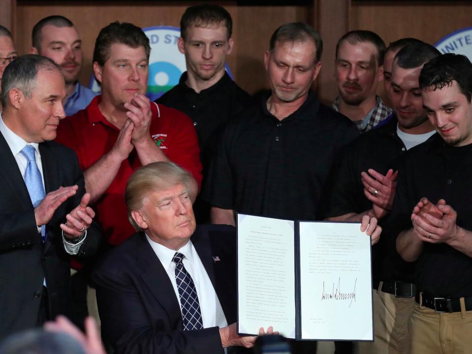 U.S. President Donald Trump holds up an executive order on