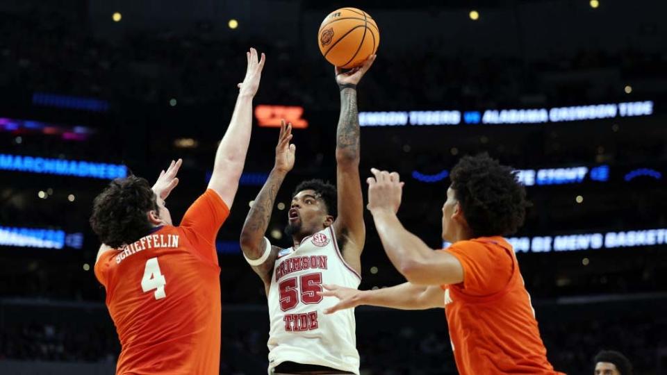  Aaron Estrada #55 of the Alabama Crimson Tide shoots the ball against Ian Schieffelin #4 of the Clemson Tigers during the first half in the Elite 8 round of the NCAA Men's Basketball Tournament . 