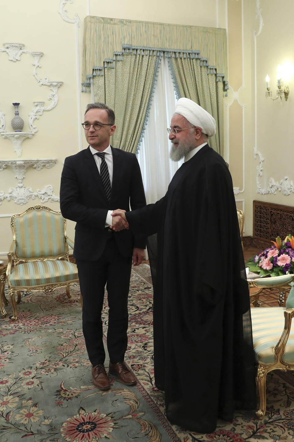 In this photo released by the official website of the office of the Iranian Presidency, President Hassan Rouhani, right, welcomes German Foreign Minister Heiko Maas for their meeting, in Tehran, Iran, Monday, June 10, 2019. (Iranian Presidency Office via AP)