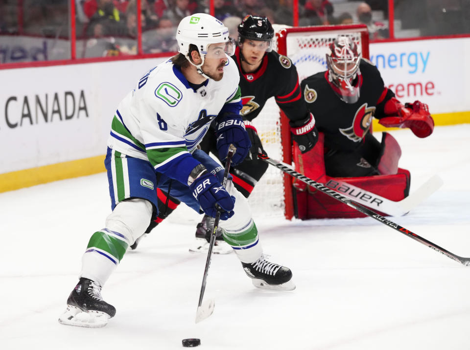 Ottawa Senators' defenseman Nick Holden (5) skates towards Vancouver Canucks' right wing Conor Garland (8) during the first period of an NHL hockey game, Wednesday, Dec.1, 2021 in Ottawa, Ontario. (Sean Kilpatrick/The Canadian Press via AP)