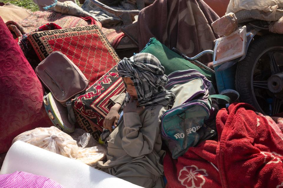 A child sits on blankets and pillows.