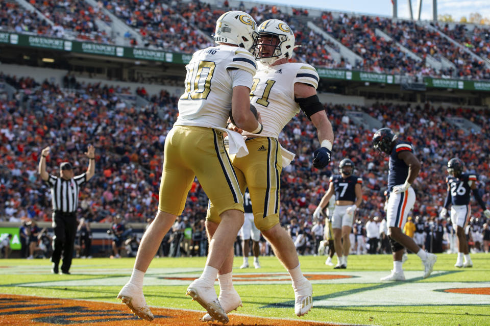 Georgia Tech quarterback Haynes King (10) celebrates with tight end Luke Benson (81) after scoring a touchdown during the first half of an NCAA college football game Saturday, Nov. 4, 2023, in Charlottesville, Va. (AP Photo/Mike Caudill)