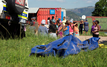 Community members look on after a body was recovered from under the mud after heavy rains caused by flooding in Marianhill near Durban, South Africa, April 25, 2019. REUTERS/Rogan Ward