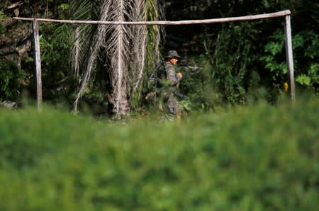 A soldier patrols during a temporary state of siege, approved by the Guatemalan Congress following the death of several soldiers last week, in the community of Semuy II, Izabal province