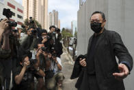 Former law professor Benny Tai, right, a key figure in Hong Kong's 2014 Occupy Central protests and also was one of the main organizers of the primaries, who was arrested under Hong Kong's national security law poses for photographers before walking in a police station in Hong Kong Sunday, Feb. 28, 2021. Hong Kong police on Sunday detained 47 pro-democracy activists on charges of conspiracy to commit subversion under the sweeping national security law. (AP Photo)