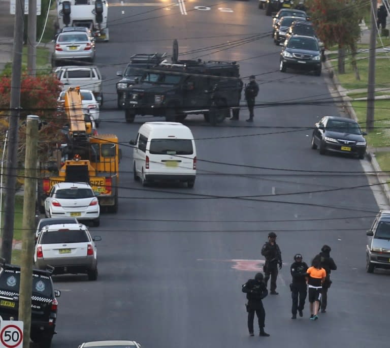 Police detain a man on a street (bottom R) in Sydney in the early morning of October 7, 2015