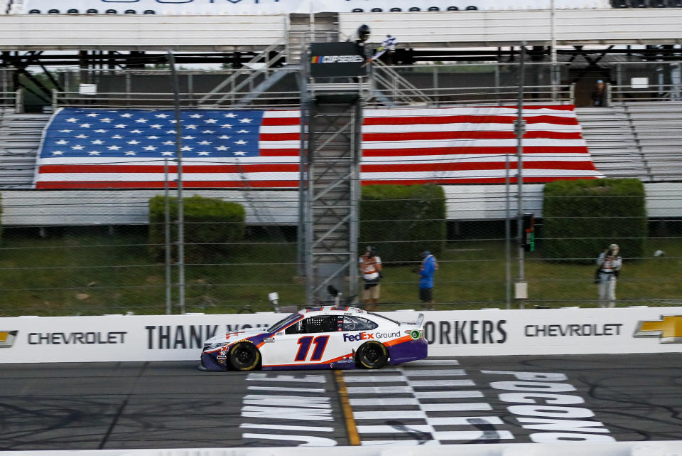 Denny Hamlin gets the checkered flag as he crosses the finish line to win the NASCAR Cup Series auto race at Pocono Raceway, Sunday, June 28, 2020, in Long Pond, Pa. (AP Photo/Matt Slocum)