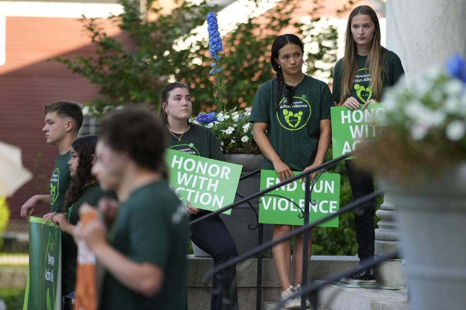 Survivors of the 2012 Sandy Hook Elementary School shooting hold signs during a rally against gun violence on Friday, June 7, 2024 in Newtown, Conn. (AP Photo/Bryan Woolston)