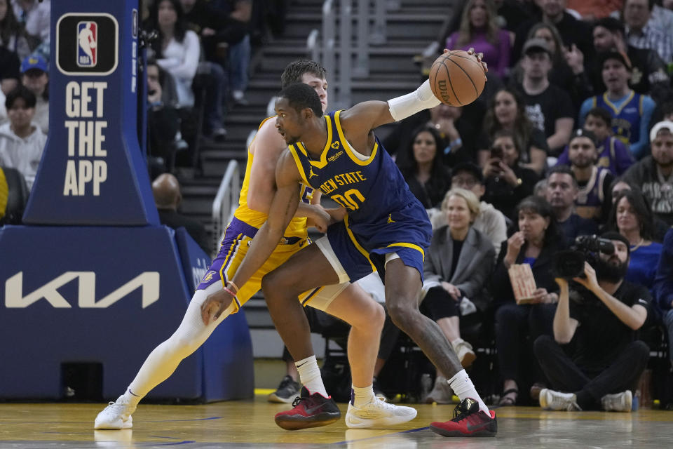 Golden State Warriors forward Jonathan Kuminga, right, is defended by Los Angeles Lakers guard Austin Reaves during the first half of an NBA basketball game in San Francisco, Thursday, Feb. 22, 2024. (AP Photo/Jeff Chiu)