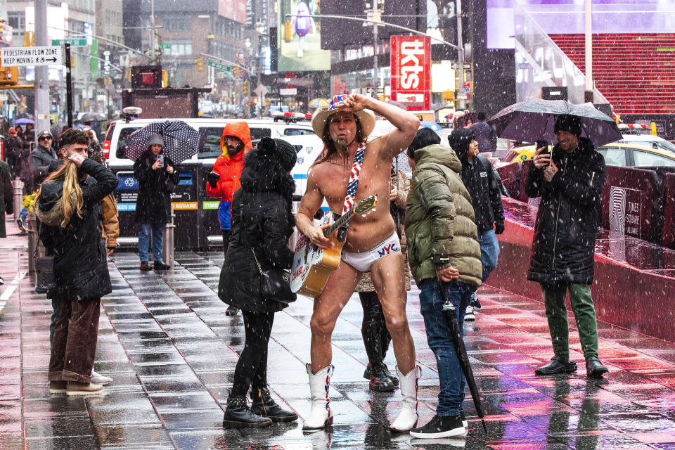 People pose for a picture near the Naked Cowboy while visiting Times Square during a winter storm in New York Sunday, Jan. 7, 2024. (AP Photo/Eduardo Munoz Alvarez)