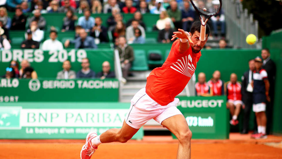 Novak Djokovic throws his racquet at the ball after trying to play a backhand. (Photo by Clive Brunskill/Getty Images)