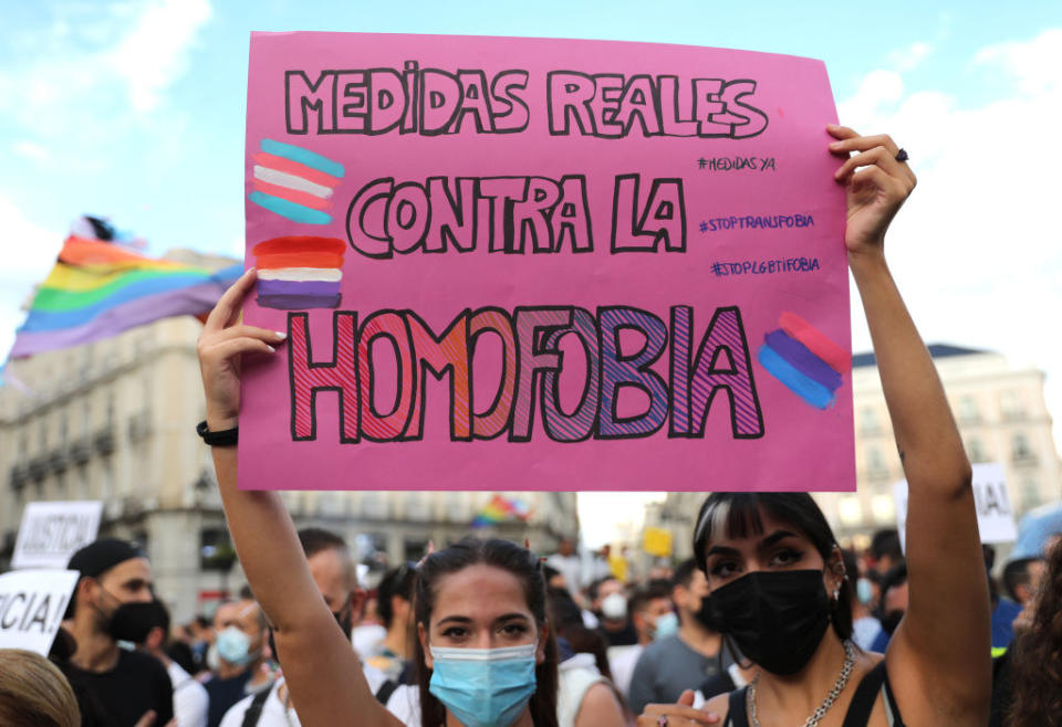 people holding a protest sign against anti-gay behavior at pride