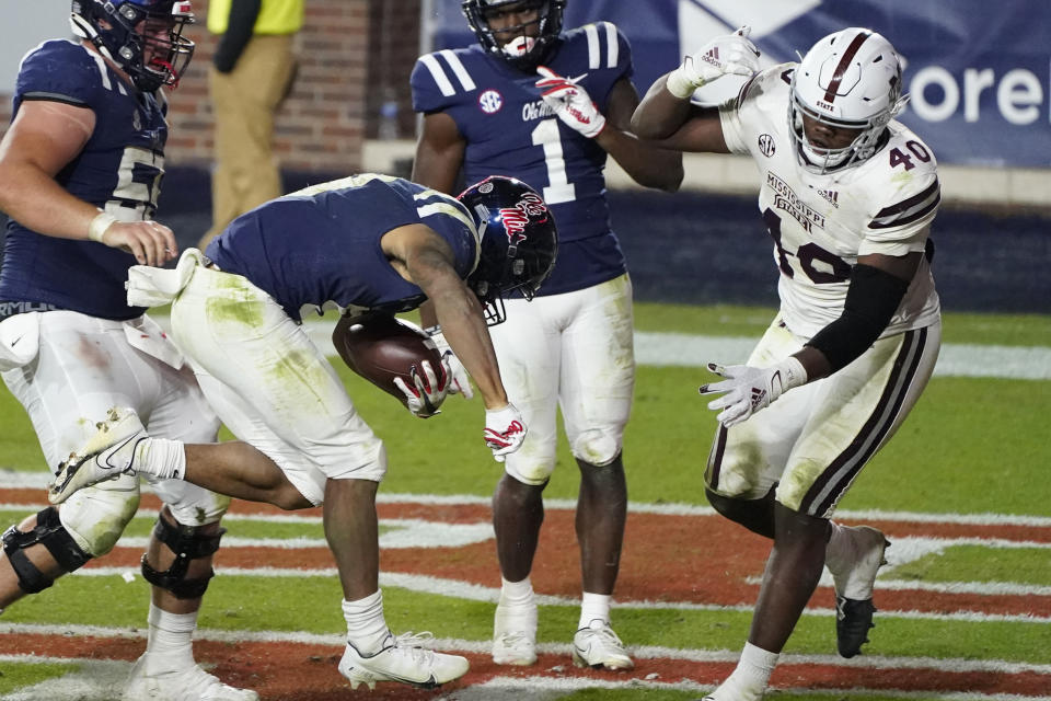 Mississippi running back Jerrion Ealy (9) follows his blockers as he rushes for a 8-yard touchdown as Mississippi State linebacker Erroll Thompson (40) comes up to defend during the second half of an NCAA college football game against Mississippi State, Saturday, Nov. 28, 2020, in Oxford, Miss. (AP Photo/Rogelio V. Solis)