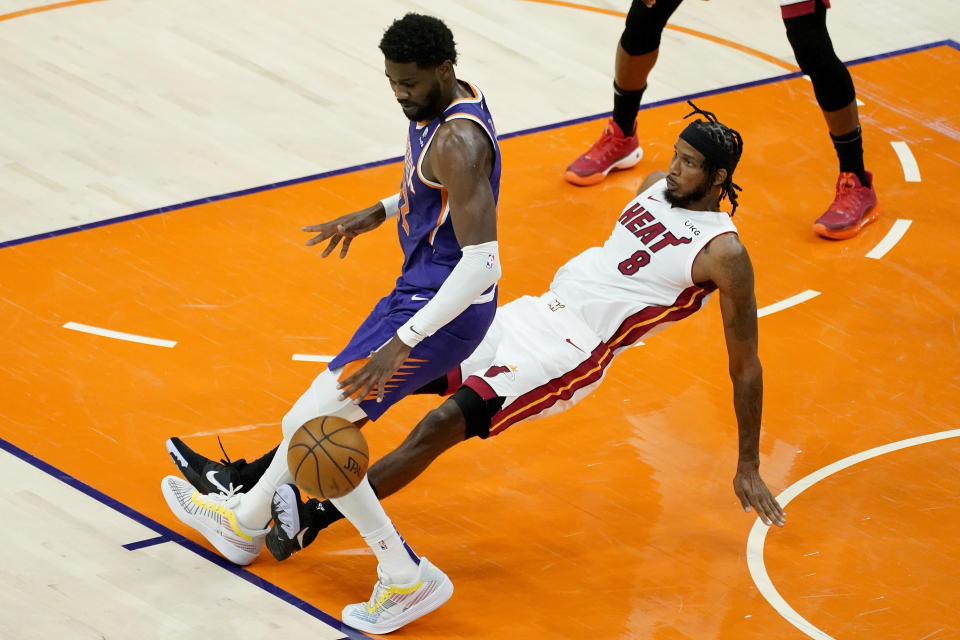 Miami Heat forward Trevor Ariza (8) fouls Phoenix Suns center Deandre Ayton during the first half of an NBA basketball game, Tuesday, April 13, 2021, in Phoenix. (AP Photo/Matt York)