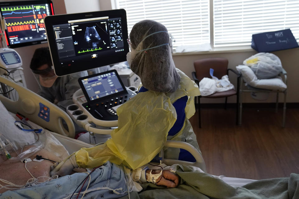 Tracy Brooks, an echocardiogram technician, takes readings from a critically ill COVID-19 patient, in an intensive care unit at the Willis-Knighton Medical Center in Shreveport, La., Tuesday, Aug. 17, 2021. The hospital in northwestern Louisiana thought the COVID-19 pandemic was letting up. Then came the ongoing surge caused by the delta variant. (AP Photo/Gerald Herbert)