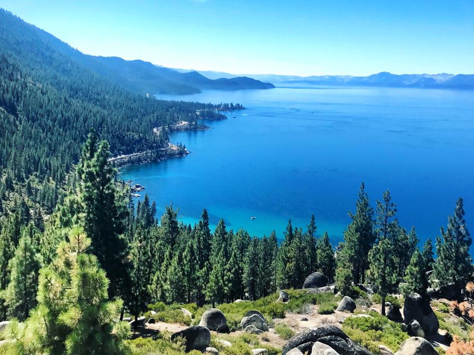 A view of Lake Tahoe from Nevada, with water, trees, and blue skies