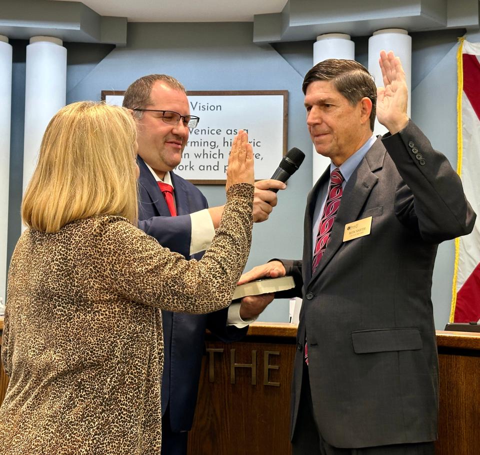 New Venice City Council Member Ron Smith, right, recites the oath of office Tuesday morning. The oath was administered by City Clerk Kelly Michaels while Venice Mayor Nick Pachota held the Bible and a microphone.