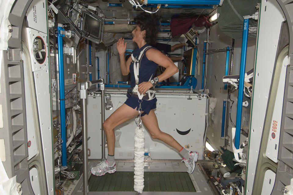 Suni Williams on a treadmill running on the international space station, while weighted down.