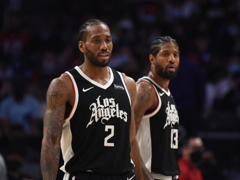 Kawhi Leonard and Paul George look on during a Clippers game in 2021.