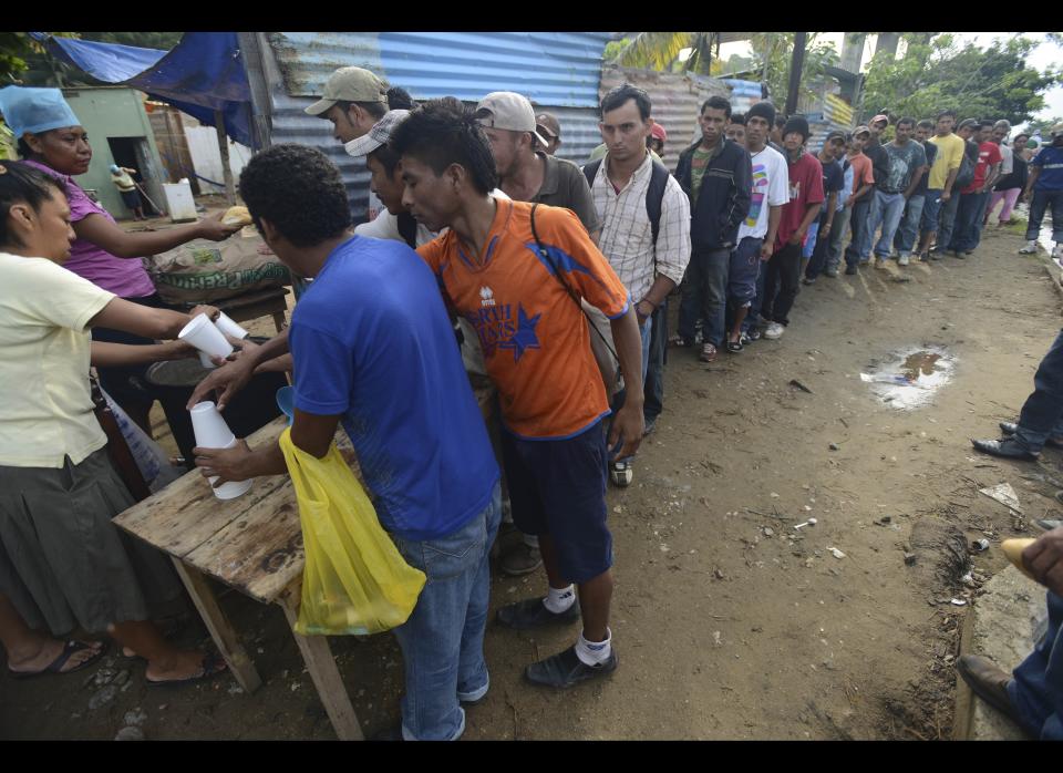 Central American migrants line up for bread and coffee during their wait for a northern bound train, in Coatzacoalcos, Mexico, Wednesday, July 11, 2012. Local officials estimate one thousand immigrants are stranded in this town after a rail bridge collapsed blocking the passage of cargo trains used by the travelers heading to the United States. While the number of Mexicans heading to the U.S. has dropped dramatically, a surge of Central American migrants is making the 1,000-mile northbound journey this year, fueled in large part by the rising violence brought by the spread of Mexican drug cartels. (AP Photo/Miguel Juarez)