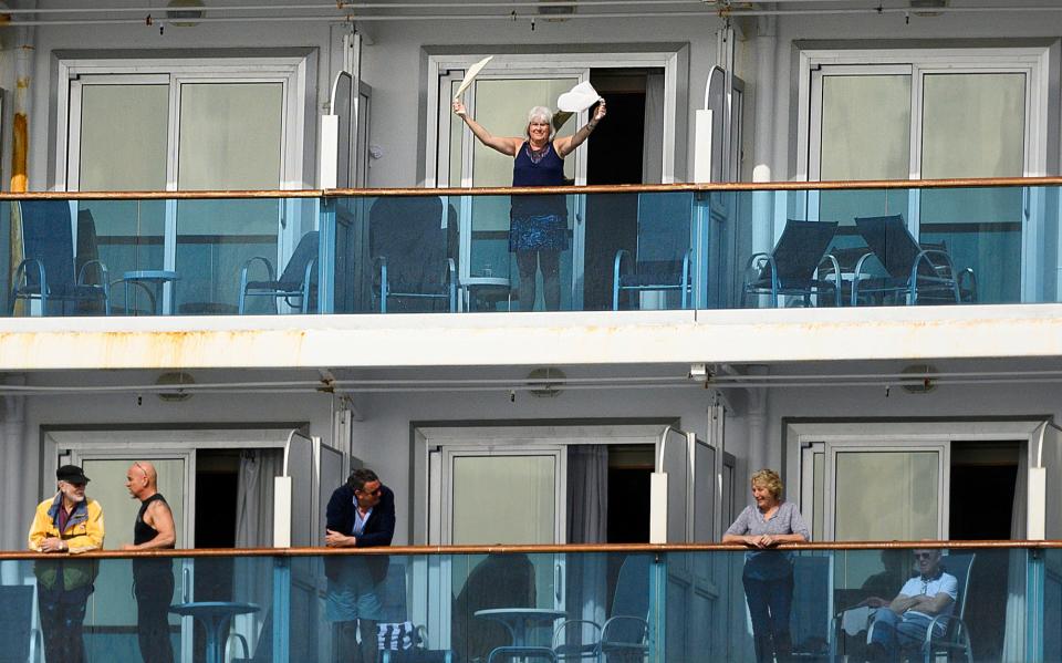 7 A passenger waves aboard the Grand Princess off the coast of San Francisco as a media boat approaches on Sunday, March 8, 2020