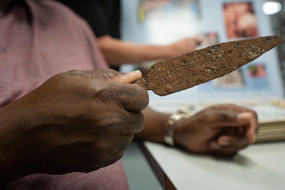 Howard Clark, descendant of blacksmith Tom Cook, looks at a nail clinching bar, used for holding nails for horseshoes.