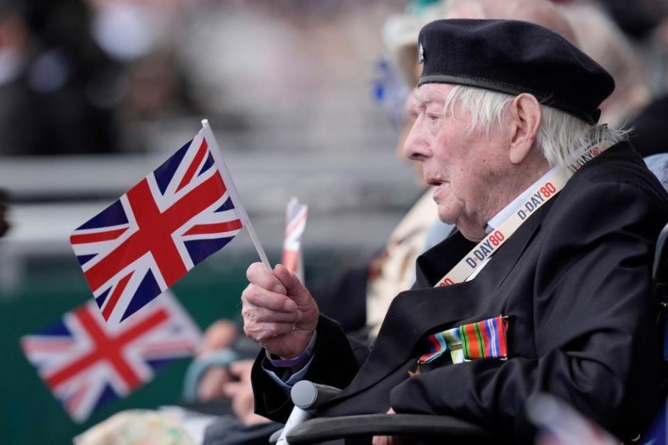 A Normandy veteran waves a flag