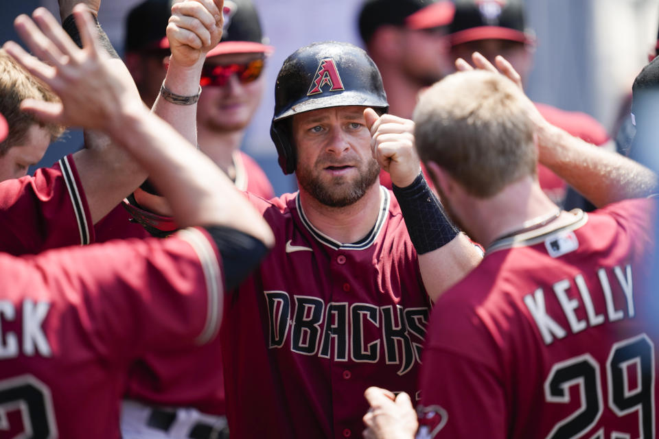 Arizona Diamondbacks' Stephen Vogt (21) celebrates with teammates in the dugout after hitting a home run during the fourth inning of a baseball game against the Los Angeles Dodgers Sunday, July 11, 2021, in Los Angeles. (AP Photo/Ashley Landis)