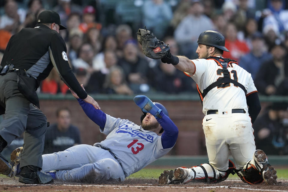 Los Angeles Dodgers' Max Muncy (13) scores past San Francisco Giants catcher Joey Bart (21) as umpire Cory Blaser watches during the fourth inning of a baseball game in San Francisco, Wednesday, Aug. 3, 2022. (AP Photo/Jeff Chiu)