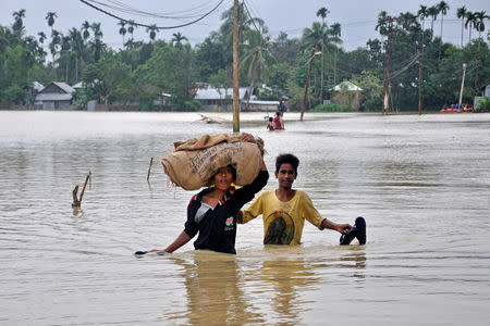 FILE PHOTO: Boys wade through a flooded village on the outskirts of Agartala, India, October 22, 2017. REUTERS/Jayanta Dey/File Photo