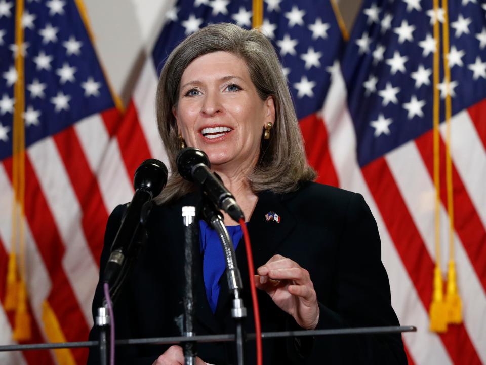 Joni Ernst speaks in front of American flags