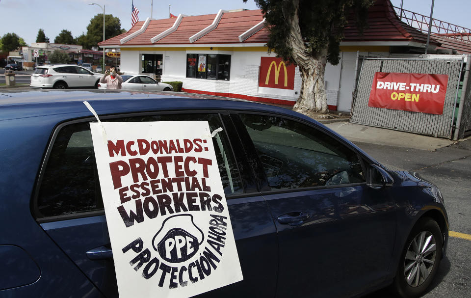 FILE - In this April 21, 2020, file photo, motorists protest what they say is a lack of personal protective equipment for employees as they shut down a McDonald's drive-thru restaurant in Oakland, Calif. Across the country, the new, unexpected front-line workers of the pandemic — from grocery store and fast food workers to Instacart shoppers and Uber drivers — are taking action to protect themselves. (AP Photo/Ben Margot, File)
