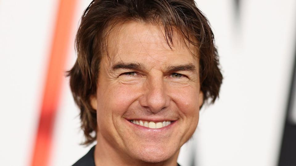 tom cruise smiling for a photo at a film premiere