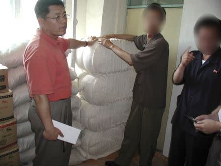 A photo provided by the Light Korean Presbyterian Church on March 5, 2015 shows Reverend Hyeon Soo Lim at an agricultural project in North Korea, with the faces of North Korean workers digitally blocked by the church to hide their identities. REUTERS/Light Presbyterian Church/Handout via Reuters