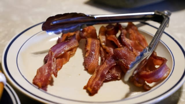 A plate of bacon sits on a kitchen table.