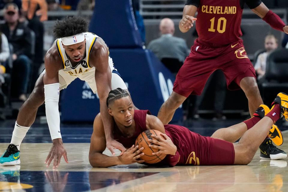 Cleveland Cavaliers forward Isaac Okoro, front right, battles for the ball with Indiana Pacers guard Buddy Hield, left, during the first half of an NBA basketball game in Indianapolis, Sunday, Feb. 5, 2023. (AP Photo/AJ Mast)