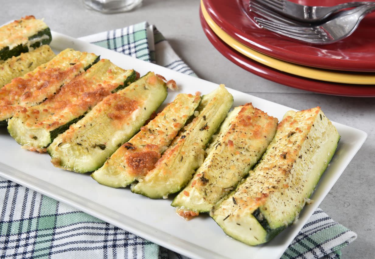 A plate of baked zucchini wedges with parmesan and garlic