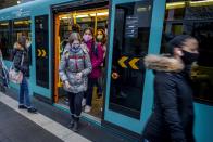 Students wear face masks as they leave a subway in Frankfurt, Germany, Wednesday, Oct. 28, 2020. (AP Photo/Michael Probst)