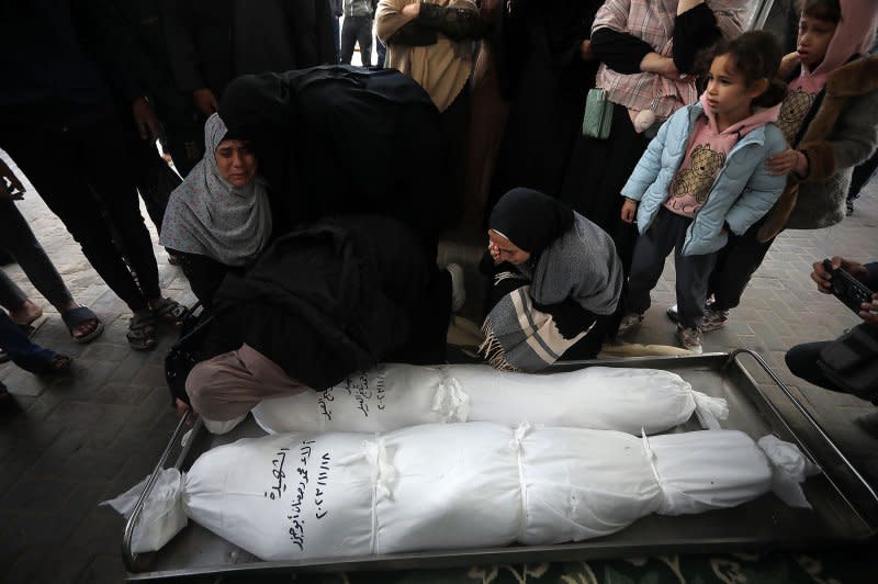 A Palestinian relative mourns over the bodies of a woman and her child from the Palestinian Sheikh el-Eed family, killed along with another child from the household a day earlier, when their home was hit by Israeli bombs in Rafah on Sunday. Photo by Ismael Muhammad/UPI