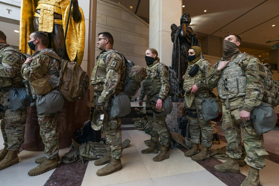 Members of the National Guard gather at inside the Capitol Visitor Center, Wednesday, Jan. 13, 2021, in Washington as the House of Representatives continues with its fast-moving House vote to impeach President Donald Trump, a week after a mob of Trump supporters stormed the U.S. Capitol. (AP Photo/Manuel Balce Ceneta)