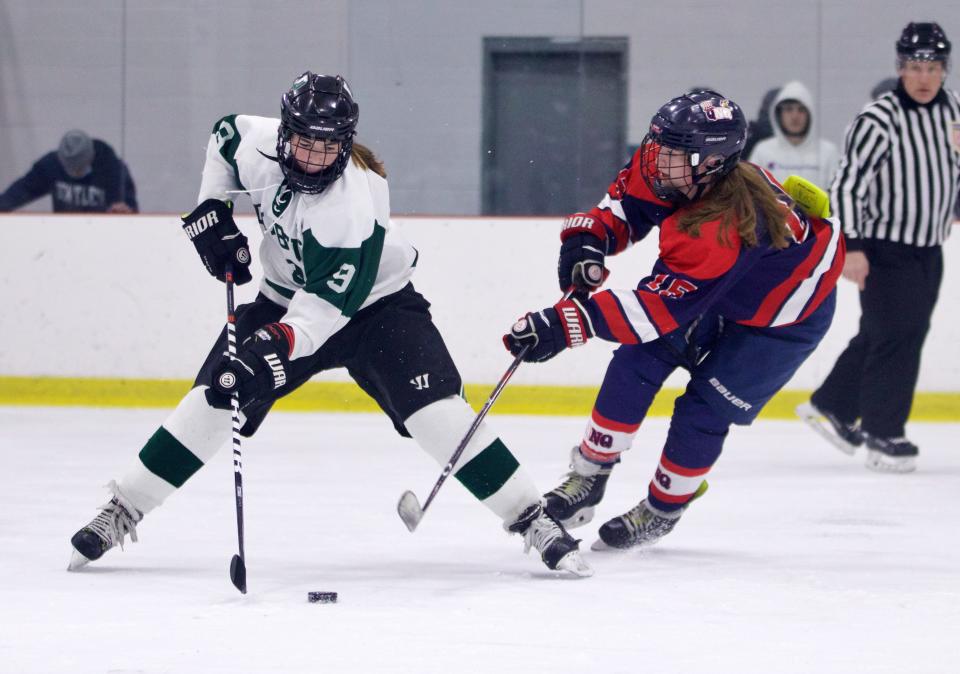 Duxbury's Ayla Abban controls the puck against North Quincy's Maggie Dineen during a game at The Bog Ice Arena in Kingston on Saturday, Dec. 18, 2021.