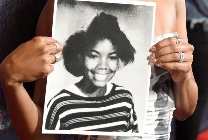 Gabrielle holding up an old photo of herself