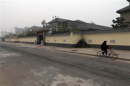 A man cycles past an unfinished residence which belongs to former People's Liberation Army (PLA) General Gu Junshan, in Puyang, Henan province January 19, 2014. REUTERS/Stringer