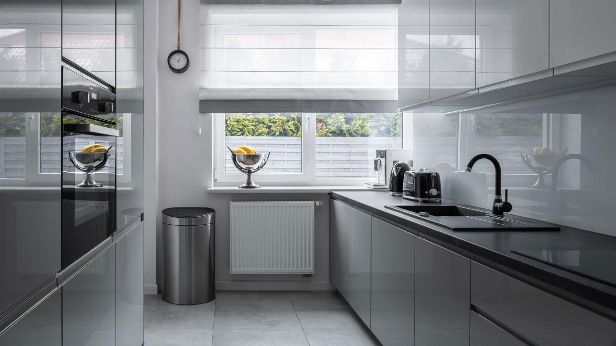  gray kitchen with stainless steel trash can 