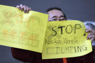 A man holds placards that read "Oppose to release contaminated water," left, and "Stop Nuclear Waste Dumping" during a protest rally against government's decision, outside the prime minister's office in Tokyo Tuesday, April 13, 2021. Japan's government decided Tuesday to start releasing treated radioactive water from the wrecked Fukushima nuclear plant into the Pacific Ocean in two years, an option fiercely opposed by fishermen, residents and Japan's neighbors. (AP Photo/Eugene Hoshiko)