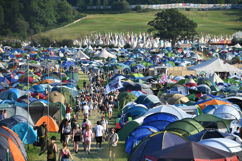 GLASTONBURY, ENGLAND - JUNE 26: Festival goers walk about the site during day one of Glastonbury Festival 2024 at Worthy Farm, Pilton on June 26, 2024 in Glastonbury, England. Founded by Michael Eavis in 1970, Glastonbury Festival features around 3,000 performances across over 80 stages. Renowned for its vibrant atmosphere and iconic Pyramid Stage, the festival offers a diverse lineup of music and arts, embodying a spirit of community, creativity, and environmental consciousness. (Photo by Jim Dyson/Redferns)