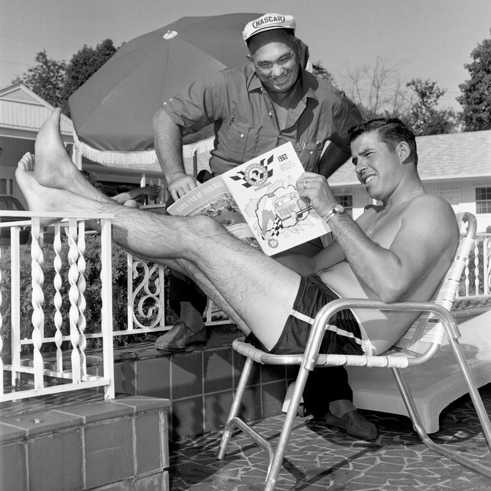 David Pearson, veteran NASCAR flagman Johnny Bruner, browses through a program while resting next to the pool at Nashville's Mercury Motel in 1963.