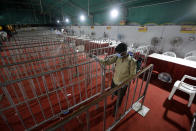 A health worker disinfects and area where tests for COVID-19 were performed, at a facility erected at a railway station to screen people coming from outside the city, in Ahmedabad, India, Friday, Sept. 18, 2020. India's coronavirus cases jumped by another 96,424 in the past 24 hours, showing little sign of leveling. India is expected to have the highest number of confirmed cases within weeks, surpassing the United States, where more than 6.67 million people have been infected. (AP Photo/Ajit Solanki)